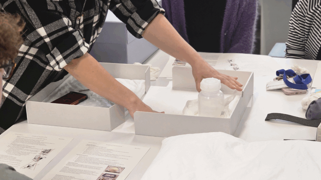 Die Restauratorin demonstriert, wie man Objekte in einem Karton sicher verpackt.