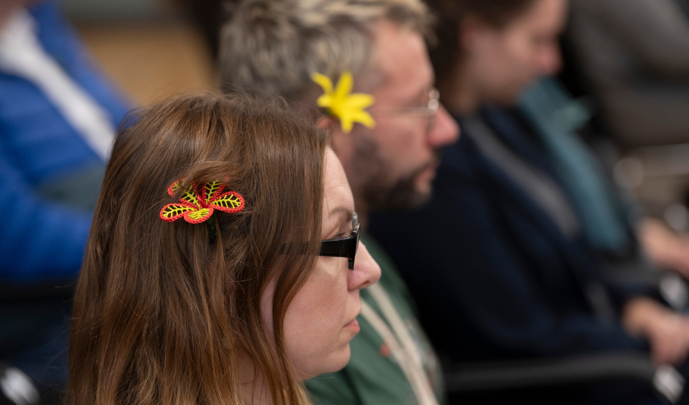 Teilnehmerin und Teilnehmer der Rückgabe-Zeremonie mit Bastblumen im Haar