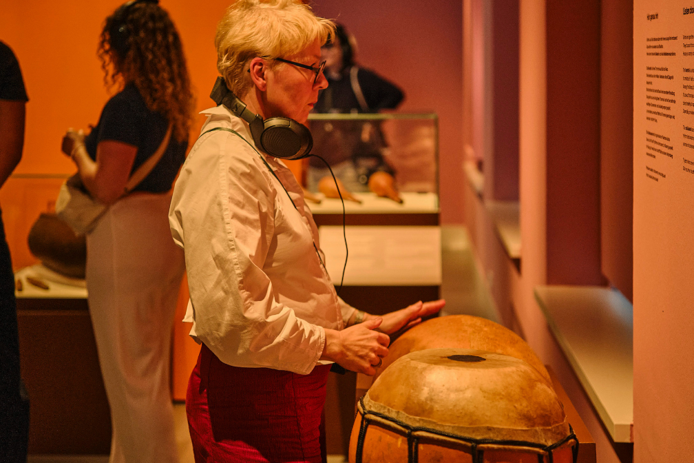 Besucherin mit Bendré in der Sonderausstellung Hört, hört im Forum Wissen