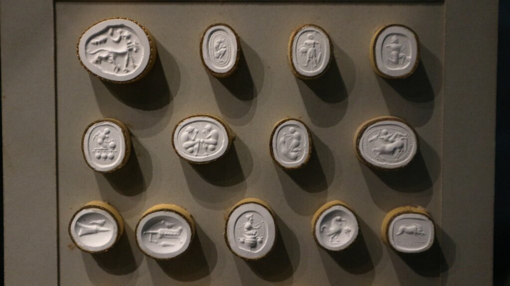 Die Abbildung zeigt Gipsabgüsse von Gemmen im Detail aus dem Sammlungsschaufenster im Forum Wissen.